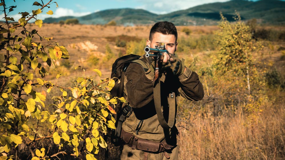 Hunter Aims Through a Scope of A Hunting Rifle